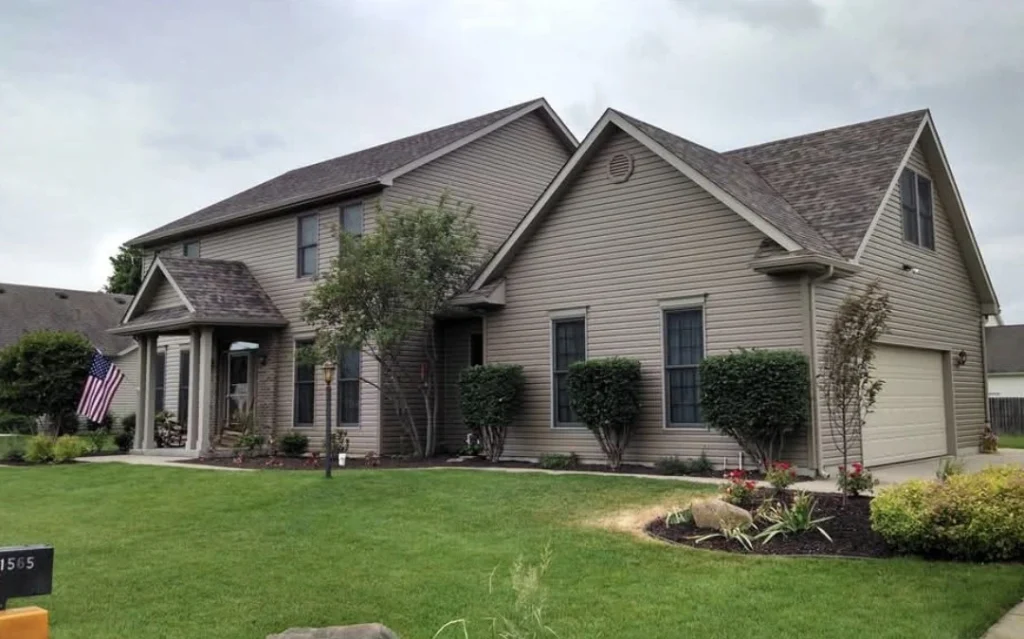 Two-story home with a shingle roof, siding exterior, and attached garage in a suburban neighborhood.